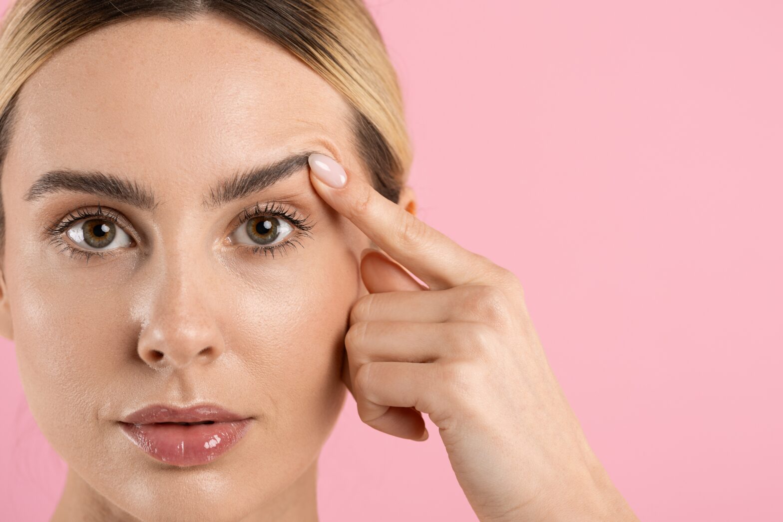 women lifting up eyebrow with finger